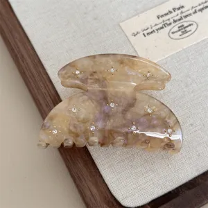 Detailed view of a retro marble acetate hair claw clip with crystal rhinestones, elegant style.