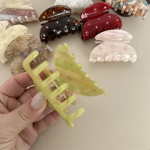 Detailed close-up of colorful acetate hair claw clip featuring sparkling rhinestone decor.