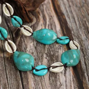 Close-up detail of bohemian turquoise marbled bead and shell handmade necklace jewelry.