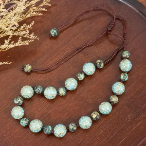 Closeup detail of retro Chinese style turquoise patterned beaded necklace, vintage handmade jewelry.