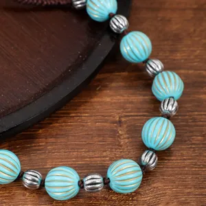 Detailed view of a vintage imitation turquoise beaded bracelet necklace with antique silver spacers.