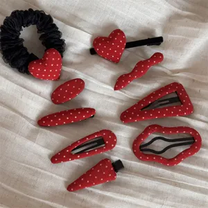 Red polka dot fabric hair clips set, detail view of cute sweet hair accessories and scrunchie.
