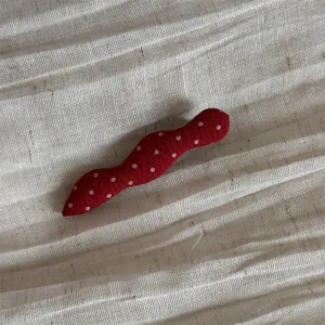Red fabric polka dot hair clip detail view, sweet Korean style hair accessory for daily styling.