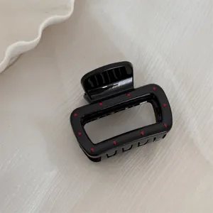 Gros plan de la pince à cheveux noire à pois rouges, accessoire de coiffure japonais mignon.