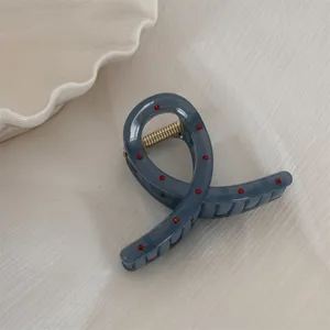 Pince a cheveux grise a pois rouges avec ressort en metal pour coiffure quotidienne.