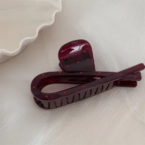 Pince à cheveux bordeaux à pois en détail, accessoire élégant en résine pour coiffure épaisse.