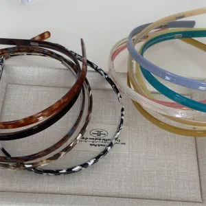 Detailed view of thin resin and tortoiseshell headbands neatly displayed on a fabric tray.