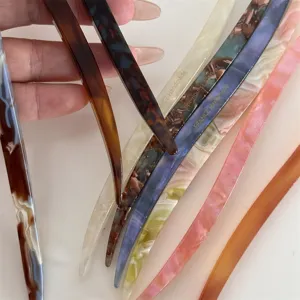 Close-up detail of stylish colorful acetate hair sticks with elegant tortoiseshell patterns.