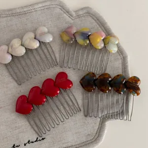 Detail shot of cute heart resin hair combs, sweet candy color side clips for women styling.