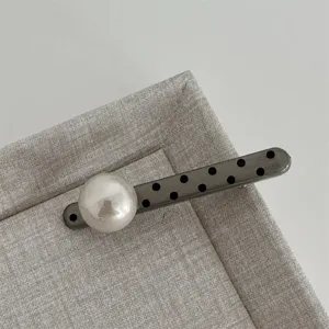 Close-up of the elegant polka dot pearl hair clip detail, showcasing the stylish design.