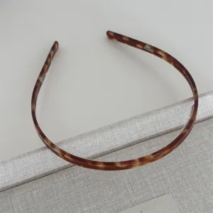 Tortoiseshell hair hoop detail view, slim design with teeth for daily wear and secure hold.