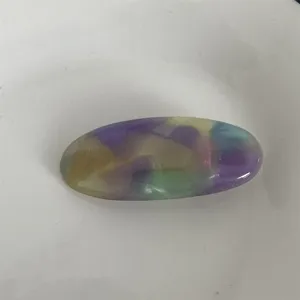 Dettaglio in primo piano della elegante molletta per capelli ovale in acetato colorato.