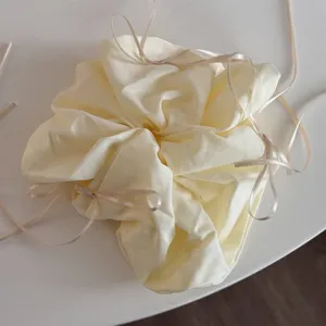 Vue détaillée de chouchou en tissu avec de charmants rubans et nœuds, style pastel chic.