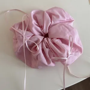 Détail de gros-plan d'un chouchou en tissu rose avec long ruban nœud, style ballet.