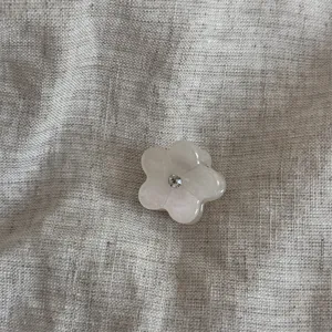 Primo piano di mini molletta per capelli a fiore gelatinoso con strass brillante.