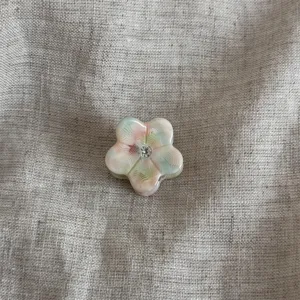Primo piano dettagliato della mini molletta per capelli a fiore con strass brillante.