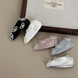 Detailed shot of ballet style leather pearl hair clips with bow design in multi colors.