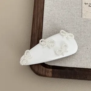 Elegant white leather pearl bow hair clip, chic side bangs hair accessory for women.
