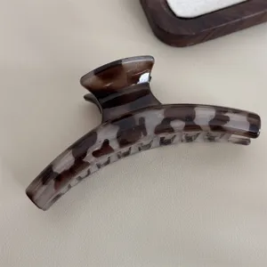 Gros plan de l'élégante pince à cheveux marron écaille pour un style quotidien raffiné.