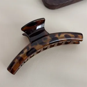Détail de pince à cheveux écaille de tortue gros plan, design marron élégant pour coiffure.