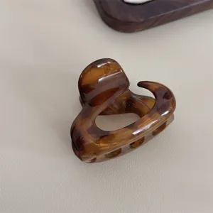 Vue détaillée de l'élégante pince à cheveux marron écaille, parfaite pour le coiffage.