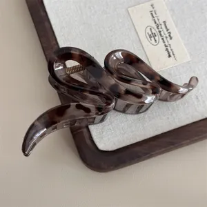 Vue détaillée de la pince à cheveux serpent en écaille marron pour un style élégant.