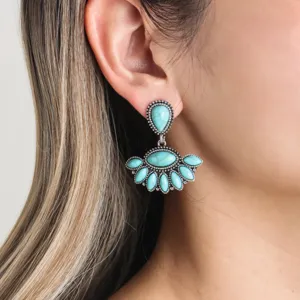 Close-up detail of bohemian turquoise fan-shaped drop earrings worn on ear, vintage style.