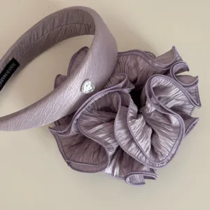 Detailed view of elegant purple pleated headband and large scrunchie set for chic hairstyles.