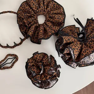 Detailansicht von stilvollen Stoff-Leoparden-Haaccessoires, Scrunchies und Haarreifen.