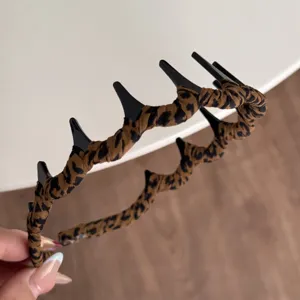 Geflochtener Haarreif mit Leopardenmuster und Zähnen, Detailansicht des Haaraccessoires.