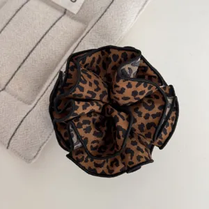 Stilvolles Stoff-Haargummi mit Leopardenmuster und schwarzem Rand, modisches Haaraccessoire.