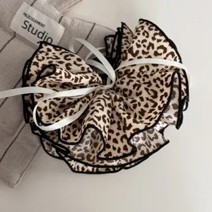 Detaillierte Ansicht des modischen Leopardenmuster Stoff-Haaraccessoires mit elegantem Wellendesign.