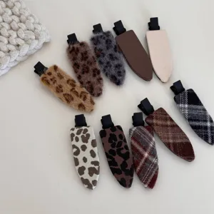Vue détaillée de pinces à cheveux en tissu imprimé léopard et à carreaux, pinces bec de canard.