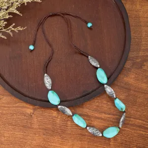 Close-up detail of the retro ethnic style necklace featuring turquoise beads and silver metal tubes.