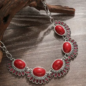 Close-up of vintage red stone statement necklace with silver alloy and sparkling crystal details.