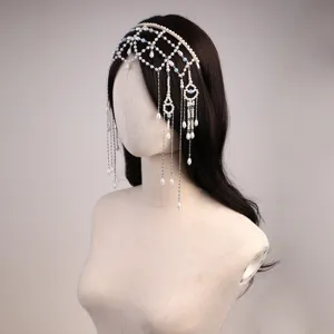 Close up detail of bridal pearl headpiece, crystal tassel chain and delicate hair accessory.