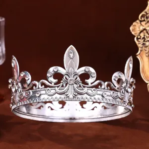 Close-up of a silver Baroque round crown adorned with sparkling rhinestones and vintage detailing.