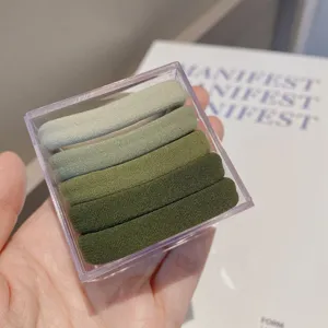 Gradient green seamless hair ties in a transparent box, soft elastic scrunchies detail view