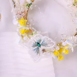 Close-up detail of handmade fairy flower crown headband with mesh butterfly and pearls.