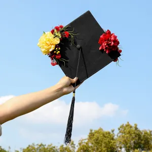 Close-up detail of handcrafted floral graduation cap with vibrant artificial flowers and tassel.