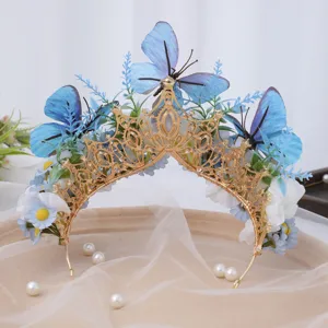 Close-up detail of the baroque gold crown tiara featuring blue butterflies and floral decor.