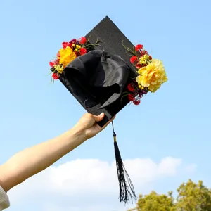 Detailed shot of a decorated graduation cap with vibrant floral arrangement and tassel.