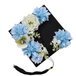 Black graduation cap adorned with blue and white artificial flowers for celebration party.