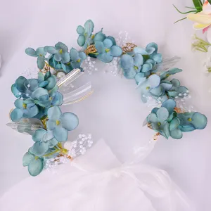 Blue forest floral headband detail showcasing intricate fabric flowers, pearls, and delicate ribbons.