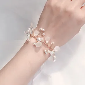 Detailopname van bruids parel polscorsage met een delicaat draadontwerp voor feesten.