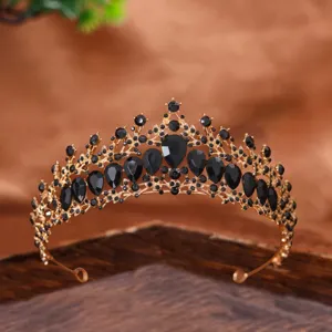 Dettaglio tiara dorata con strass neri su un design di corona in metallo decorativo per eventi.