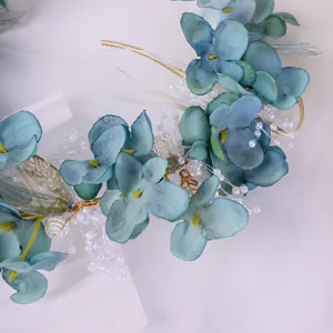 Blue forest style floral headband detail, featuring fabric silk flowers, pearls, and gold leaves.