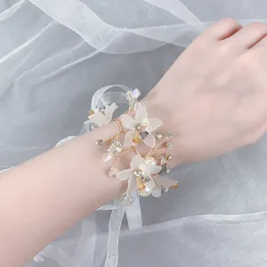 Prachtige elegante trouw polscorsage met parels en bloemen voor bruid en bruidsmeisjes.