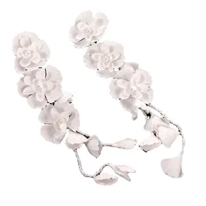 White floral bridal hair vine with pearl accents and delicate hanging beaded chains for wedding.