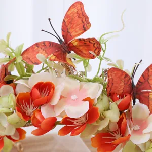 Detail view of baroque floral crown headpiece with orange silk flowers and butterflies for photoshoot.